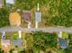 An aerial view of a single-Gathering home on a lot with lush vegetation and a paved driveway at 3883 Dominic St, North Port, FL 34288