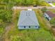 An aerial view of a single-Gathering home showing the backyard, grass, and surrounding trees at 3883 Dominic St, North Port, FL 34288