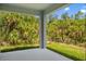 Covered back porch with mature landscaping and views of the green wooded backyard at 3883 Dominic St, North Port, FL 34288