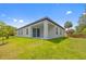 An exterior view of a single-Gathering home showing the back porch, sliding glass door, and lawn at 3883 Dominic St, North Port, FL 34288