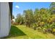 A beautiful, green backyard with trees and an exterior view of a single-Gathering home at 3883 Dominic St, North Port, FL 34288