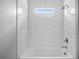 Modern bathroom with a white tub and shower featuring white subway tile and bronze fixtures at 3883 Dominic St, North Port, FL 34288