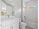 Bright bathroom featuring a white vanity with quartz countertop and subway-tiled shower-tub combo at 3883 Dominic St, North Port, FL 34288