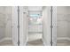En-suite bathroom view through closet doorway shows double vanity, modern fixtures and hardware at 3883 Dominic St, North Port, FL 34288