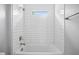 Modern bathroom with a white tub and shower featuring white subway tile and bronze fixtures at 3883 Dominic St, North Port, FL 34288