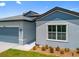 Well-maintained single-Gathering home featuring a serene blue exterior, an attached garage, and tidy landscaping at 3883 Dominic St, North Port, FL 34288