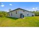 An exterior view of a single-Gathering home showing the side and backyard with lawn at 3883 Dominic St, North Port, FL 34288