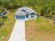 Aerial view of a beautifully landscaped new home with a blue garage door and lush green lawn at 3883 Dominic St, North Port, FL 34288