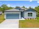 Charming single-story home featuring a two-car garage, manicured lawn, and modern architectural details at 3883 Dominic St, North Port, FL 34288
