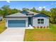 Inviting single-Gathering home with a blue color scheme, attached garage, and a lush green lawn at 3883 Dominic St, North Port, FL 34288