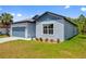 Charming single-Gathering home showcasing a light blue exterior, an attached garage, and a well-manicured lawn at 3883 Dominic St, North Port, FL 34288