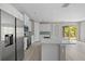 Modern kitchen with stainless steel appliances, a large island, white cabinetry, and access to the living area at 3883 Dominic St, North Port, FL 34288