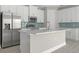 Modern kitchen features stainless steel appliances, a spacious island, sleek white cabinetry, and tiled backsplash at 3883 Dominic St, North Port, FL 34288