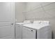 Well-equipped laundry room with side-by-side washer and dryer and a wire shelf for storage at 3883 Dominic St, North Port, FL 34288