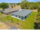 Aerial showcases the home with a back patio, bright green lawn, and nearby canal at 4131 Bula Ln, North Port, FL 34287