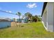 Spacious backyard featuring lush green grass, young trees, and view of neighboring homes at 4131 Bula Ln, North Port, FL 34287