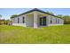 Back of house featuring a covered porch and a sprawling grassy lawn at 4131 Bula Ln, North Port, FL 34287