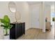Inviting entryway featuring modern decor, stylish cabinet, round mirrors, and durable flooring at 4131 Bula Ln, North Port, FL 34287