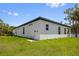 Corner view of a white home with a black roof, bright green grass, and a clear blue sky at 4131 Bula Ln, North Port, FL 34287