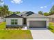 Charming single-story home with a well-manicured lawn, gray roof, and a two-car garage at 4131 Bula Ln, North Port, FL 34287