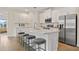 Kitchen boasts white cabinets, stainless steel appliances, and an expansive island with stool seating at 4131 Bula Ln, North Port, FL 34287