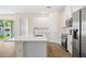 Bright kitchen boasts white cabinets, stainless appliances, a spacious island and wood-look floors at 4131 Bula Ln, North Port, FL 34287