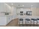 Modern kitchen features white cabinets, stainless steel appliances, and a spacious island with seating at 4131 Bula Ln, North Port, FL 34287