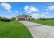 Well-manicured front yard with a long driveway leading to a charming single-story home with a two-car garage at 4637 Irdell Ter, North Port, FL 34288