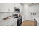 Bright kitchen featuring stainless steel appliances, quartz countertops, and white herringbone backsplash at 4637 Irdell Ter, North Port, FL 34288