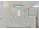 Bathroom with a double vanity, marble countertops, white cabinets, subway tile, and natural light at 1100 S Wapello St, North Port, FL 34286