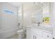 Bathroom featuring tub, toilet, sink, marble countertops, white subway tile, and a window at 1100 S Wapello St, North Port, FL 34286