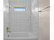 Tiled tub/shower with window and shower head at 1100 S Wapello St, North Port, FL 34286