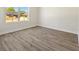 Well-lit bedroom boasts wood floors, neutral walls, and a bright window at 1100 S Wapello St, North Port, FL 34286