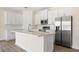 Spacious kitchen with white cabinetry, modern stainless appliances, and an eat-in island at 1100 S Wapello St, North Port, FL 34286