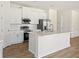 Bright kitchen features white cabinets, stainless steel appliances, marble countertops, and hardwood floors at 1100 S Wapello St, North Port, FL 34286