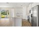 Open-concept kitchen featuring white cabinets, stainless steel appliances, and a central island at 1100 S Wapello St, North Port, FL 34286