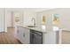 Modern kitchen island with stainless steel dishwasher, sink, marble countertop, and hardwood floors at 1100 S Wapello St, North Port, FL 34286