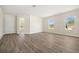 Spacious living area with wood-look floors and lots of natural light from multiple windows at 1100 S Wapello St, North Port, FL 34286