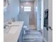 Bathroom with walk-in shower, double vanity, and gray tile flooring at 1450 Kiwi Ct, Punta Gorda, FL 33950