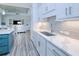 Modern kitchen with white cabinets, quartz countertops, and teal island at 1450 Kiwi Ct, Punta Gorda, FL 33950