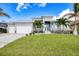 Modern house exterior with three-car garage and manicured lawn at 1450 Kiwi Ct, Punta Gorda, FL 33950
