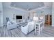 Living room with white sofas, built-in shelving, and a large TV at 1450 Kiwi Ct, Punta Gorda, FL 33950