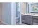 Bathroom with gray vanity, white toilet and floor, and a mirrored medicine cabinet at 1450 Kiwi Ct, Punta Gorda, FL 33950