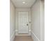 This is an entryway showcasing a white door with six panels and a textured wall, creating a simple, clean aesthetic at 16307 Alcira Cir, Punta Gorda, FL 33955
