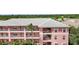 Exterior view of a two-story pink condo building with gray roof at 2061 Willow Hammock Cir # 208, Punta Gorda, FL 33983