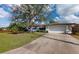 Front view of a ranch-style home with a driveway and lawn at 2376 Auburn Blvd, Port Charlotte, FL 33948