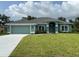 Charming single-story home with a well-manicured lawn, attached two-car garage, and light blue exterior at 27462 Pasto Dr, Punta Gorda, FL 33983