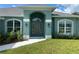 Charming home featuring a covered front entrance, arched windows, and meticulously maintained landscaping at 27462 Pasto Dr, Punta Gorda, FL 33983
