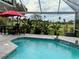 Inviting pool area with screened enclosure, overlooking a golf course at 5101 Pine Shadow Ln, North Port, FL 34287