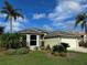 One-story house with tile roof, landscaping, and two palm trees at 5101 Pine Shadow Ln, North Port, FL 34287